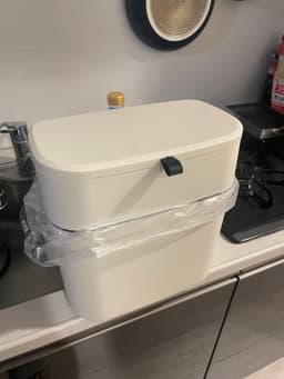 A kitchen trash can with a lid