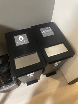 Two trash cans with labels
